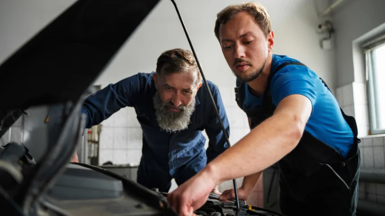 Mechanici opravují motor vozu v dílně.