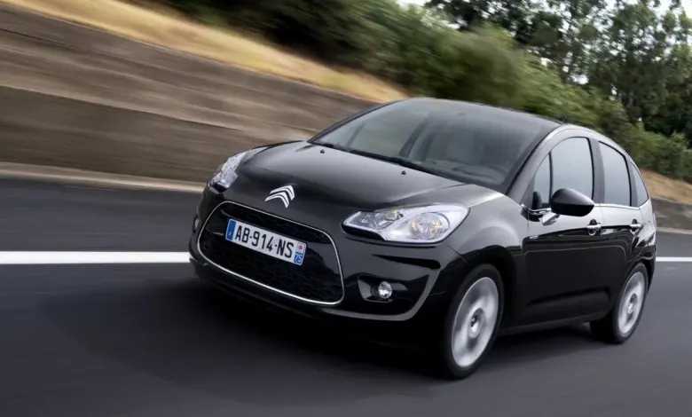 Černý automobil Citroën C3 Picasso jezdí po silnici.