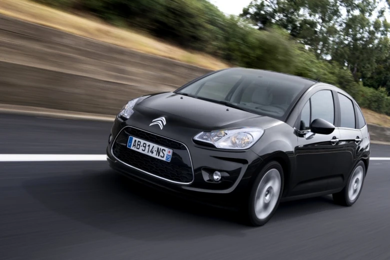 Černý automobil Citroën C3 Picasso jezdí po silnici.