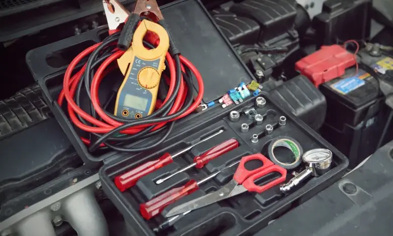Nástroje pro kontrolu funkčnosti automobilové baterie pod kapotou.