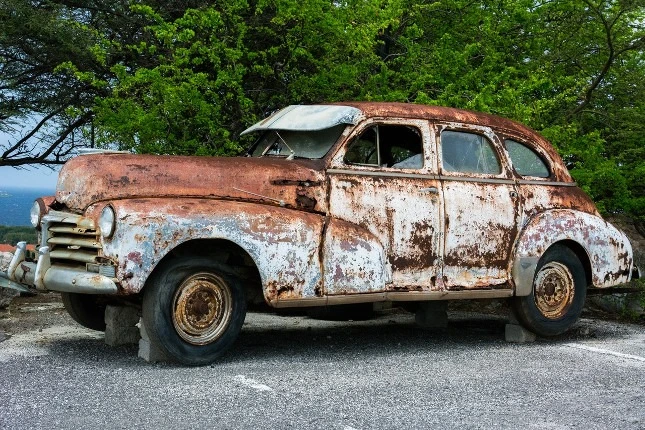 Rusty old car showing wear from kilometers driven.