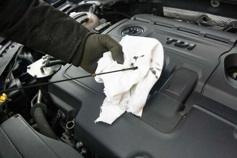 Kontrola hladiny oleje v motoru pomocí lžíce.