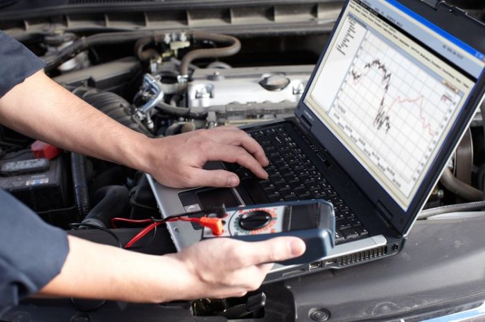 Mechanik používá diagnostický skener pro automobil pod kapotou.