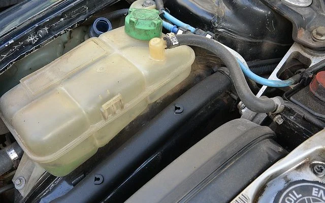 Prozředěná nádrž chladicí kapaliny v motorovém prostoru automobilu.