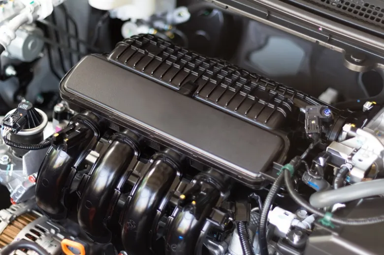 Detailní pohled na motorový prostor s černým nasáváním.