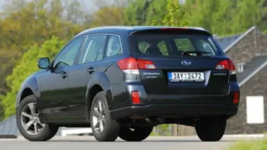 Modrý Subaru Outback zaparkovaný na silnici před domem.