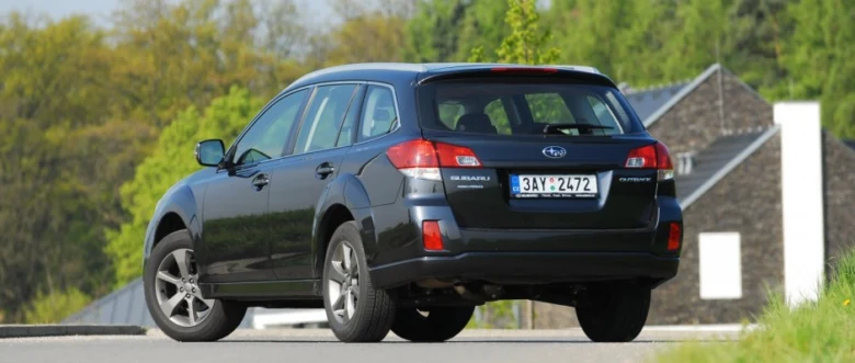 Modrý Subaru Outback zaparkovaný na silnici před domem.