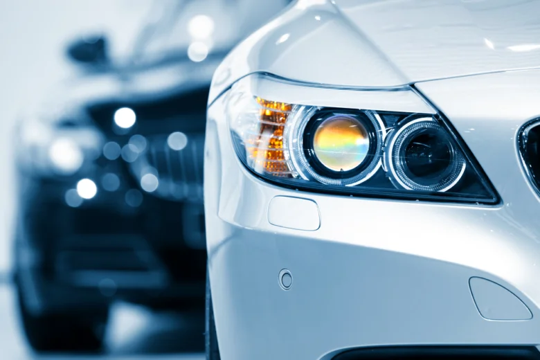 Detailní záběr na světlomět automobilu s rozsvíceným modrým světlem.