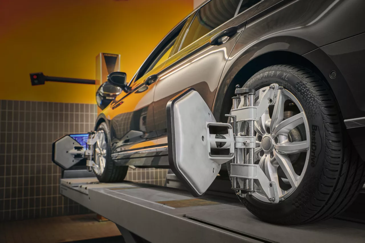 Automobil na zvedáku s nástavcem pro seřízení kol.