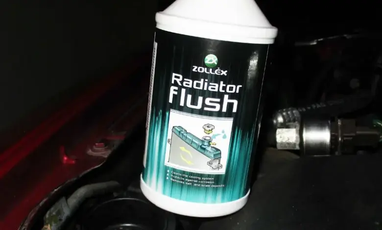 Fľaša s čističem chladiče v motorovém prostoru auta.