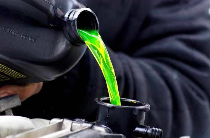 Zelená chladicí kapalina se nalévá do radiátoru automobilu.