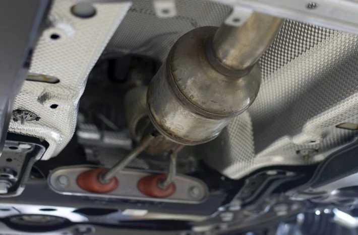 Podvozek automobilu s viditelným katalyzátorem výfukového systému.