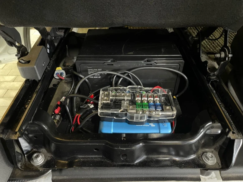 Přídavná baterie s pojistkovým blokem v kufru auta po instalaci.