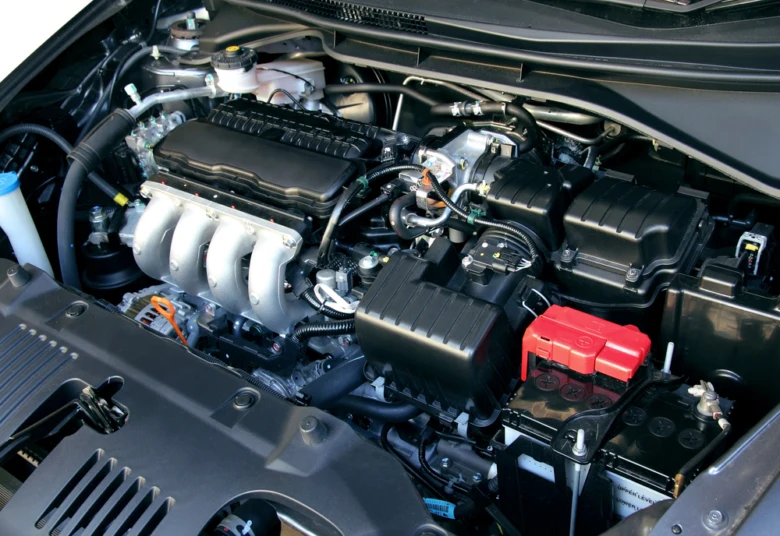 Detailní pohled do motorového prostoru benzínového automobilu s viditelnými komponenty.