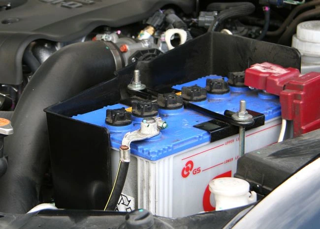 Autobaterie s odpojeným kladným pólem v motorovém prostoru.