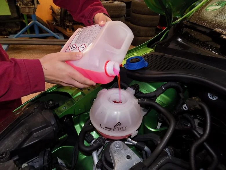 Doplňování nemrznoucí kapaliny do rozšiřovací nádrže motoru.