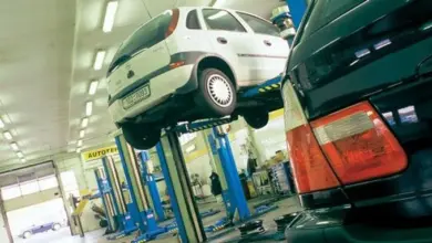 Bílý automobil na zvedáku v servisu