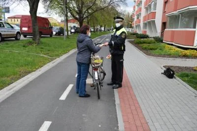 Policiista kontroluje cyklistku na jízdním kole.