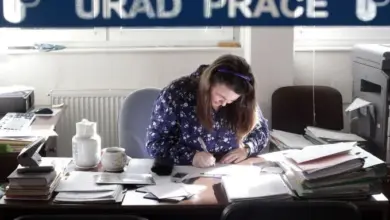 Žena pracuje v kanceláři s dokumenty na stole.