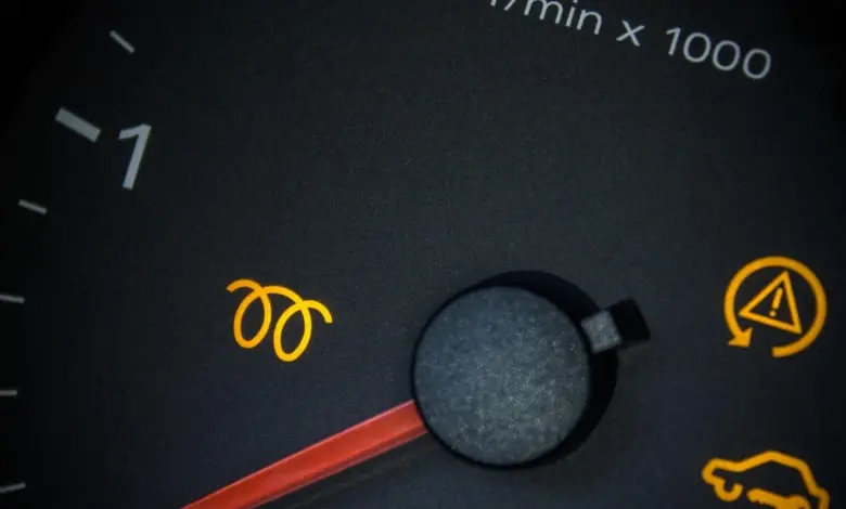 Žluté varovné lampy na přístrojové desce automobilu.