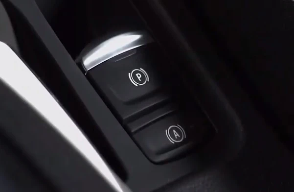 Blízký záběr na tlačítka parkování P a Autohold A v interiéru auta.