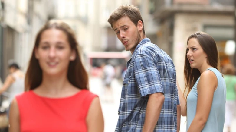 Muž se podívá zpět na ženu při chůzi po ulici.