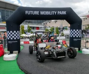 Černé závodní auto pod nafukovacím obloukem na akcích mobility.