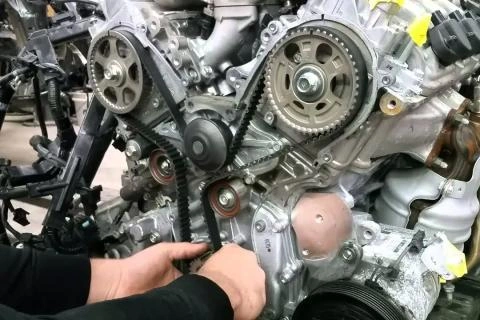 Mechanik opravuje rozvodový řemen u motoru vozu značky Peugeot nebo Citroën.