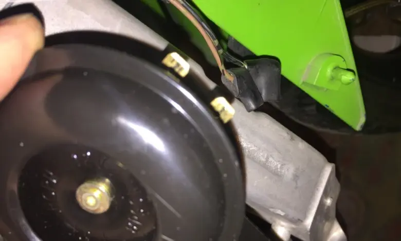 Černý klakson s připojenými vodiči u motoru