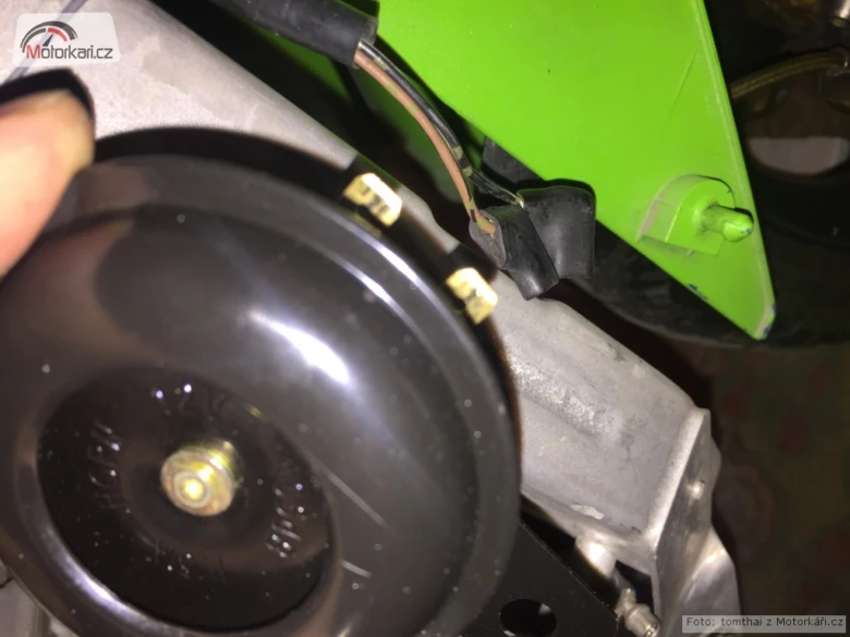Černý klakson s připojenými vodiči u motoru