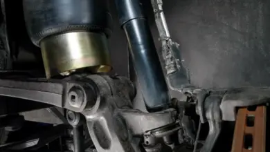 Detailní pohled na tlumiče a podvozky pro zvedání kufru auta.