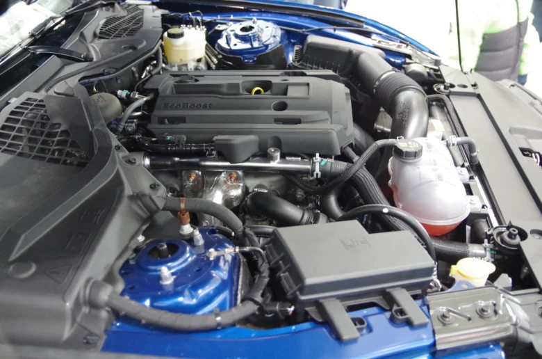 Modrý motor Ford EcoBoost pod kapotou s viditelnými komponenty.
