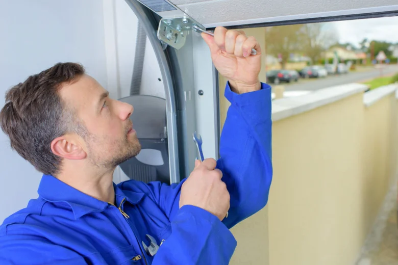 Mechanik opravuje automatizované garážové brány pomocí nářadí.
