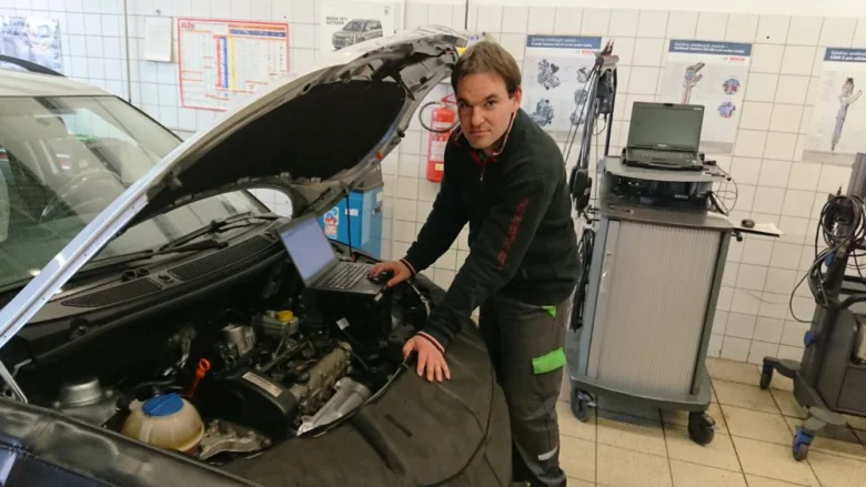 Mechanik pracuje na motoru Škody Fabia v dílně.