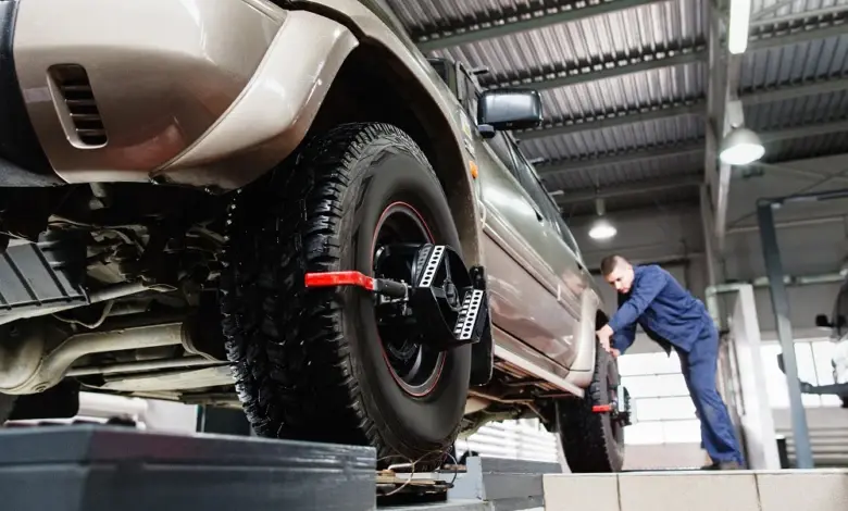 Mechanik nastavuje geometrii kol na zvedáku v dílně