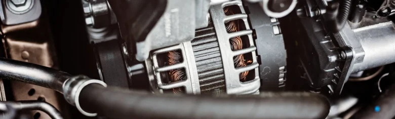 Detailní pohled na automobilový alternátor v motorovém prostoru.