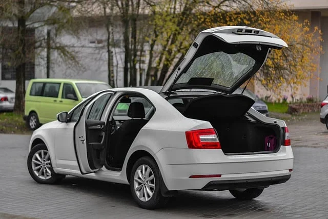 Bílá Škoda Octavia s otevřenými dveřmi a zavazadlovým prostorem.