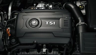 Motor automobilu s logem značky pod kapotou.