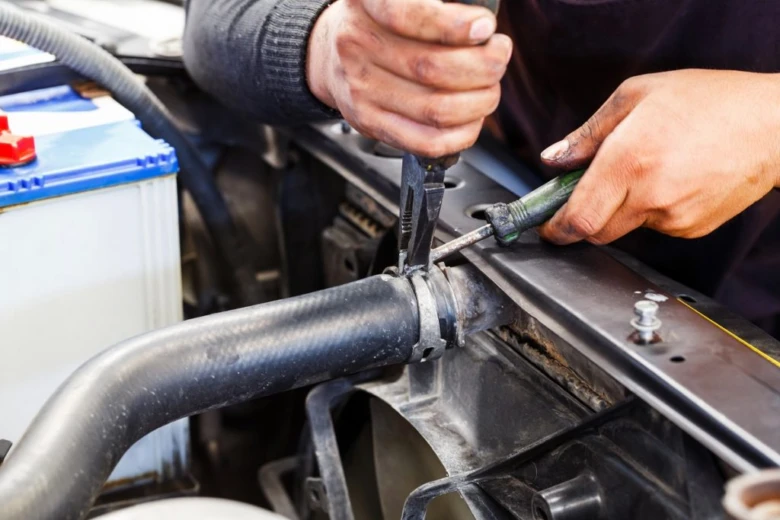 Mechanik opravuje hadici v motoru po zamrznutí vody.