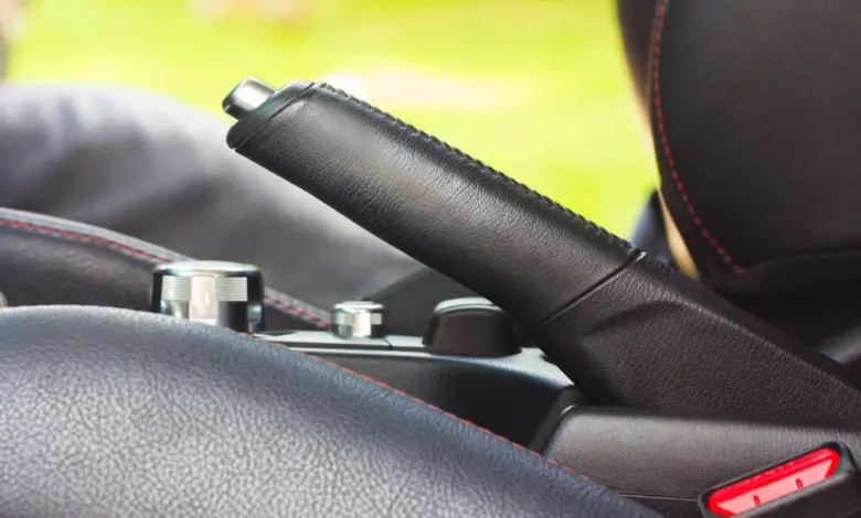 Blízký záběr na ruční brzdu v interiéru automobilu.