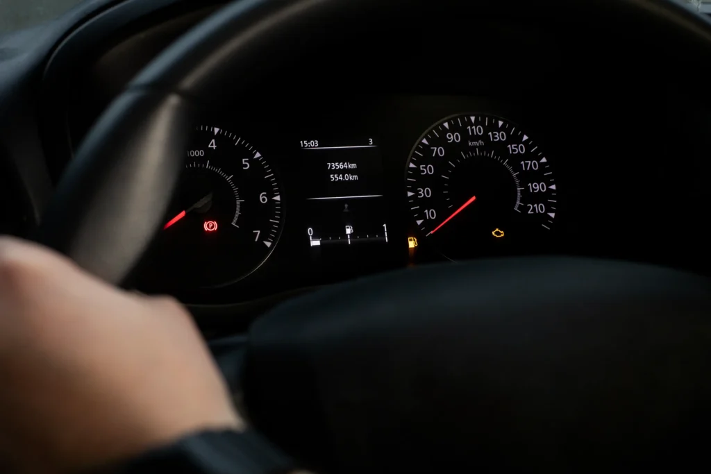 Zapnutá kontrolka motoru na přístrojové desce auta.