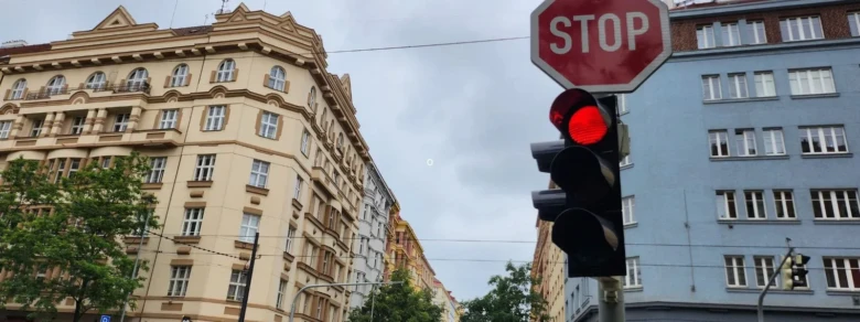 Červená světla na semaforu s dopravní značkou STOP u křižovatky.