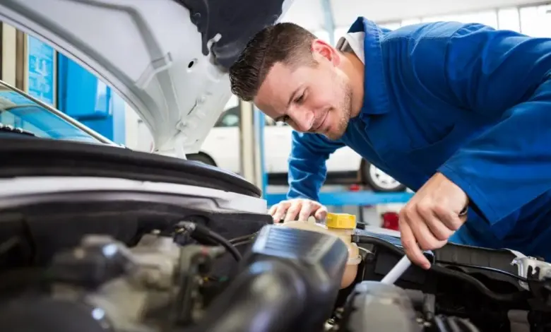 Mechanik opravuje motor vozu v dílně.