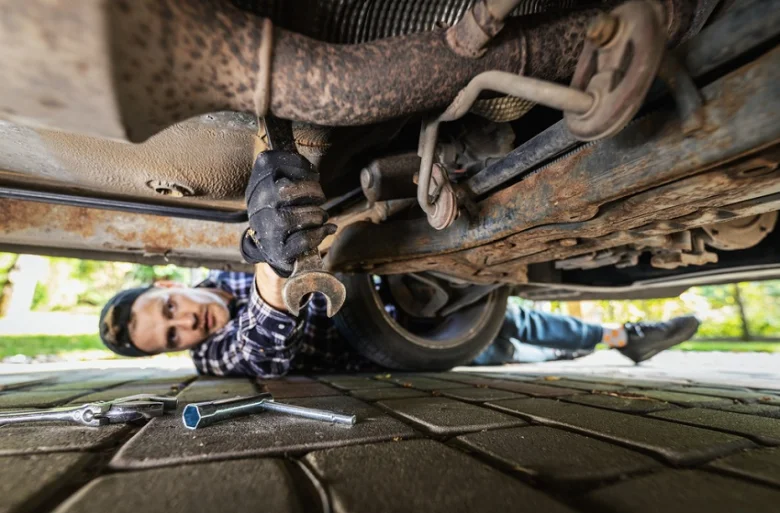 Mechanik opravuje podvozek auta pomocí klíče