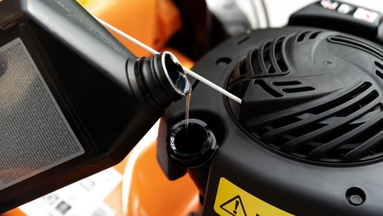 Nalévání motorového oleje do sekačky na trávu.