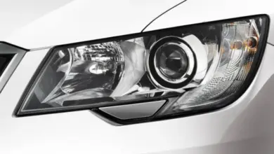 Blízký záběr na světlomet automobilu s viditelnou žárovkou.