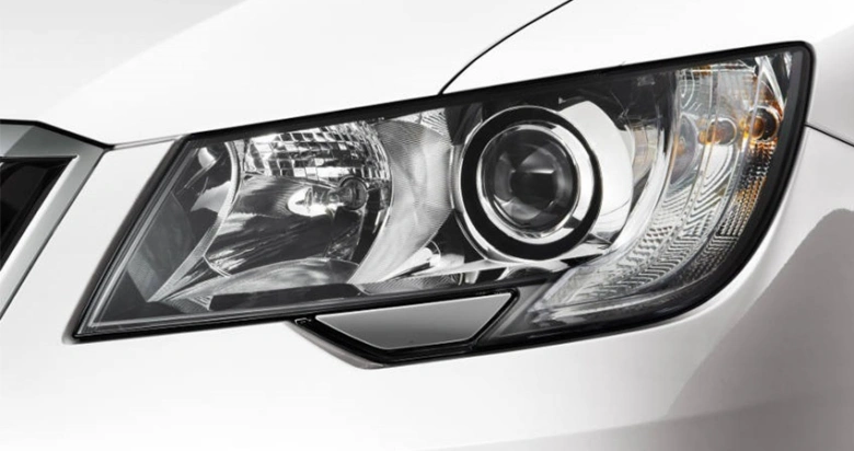 Blízký záběr na světlomet automobilu s viditelnou žárovkou.