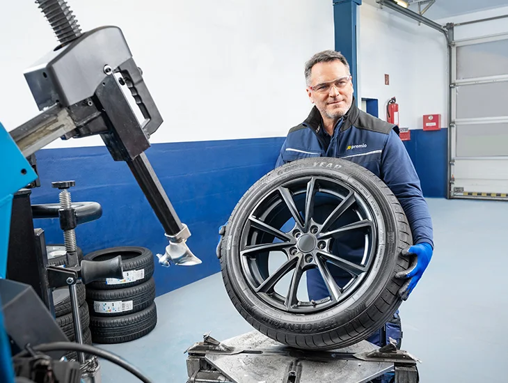 Mechanik drží disk s pneumatikou v dílně