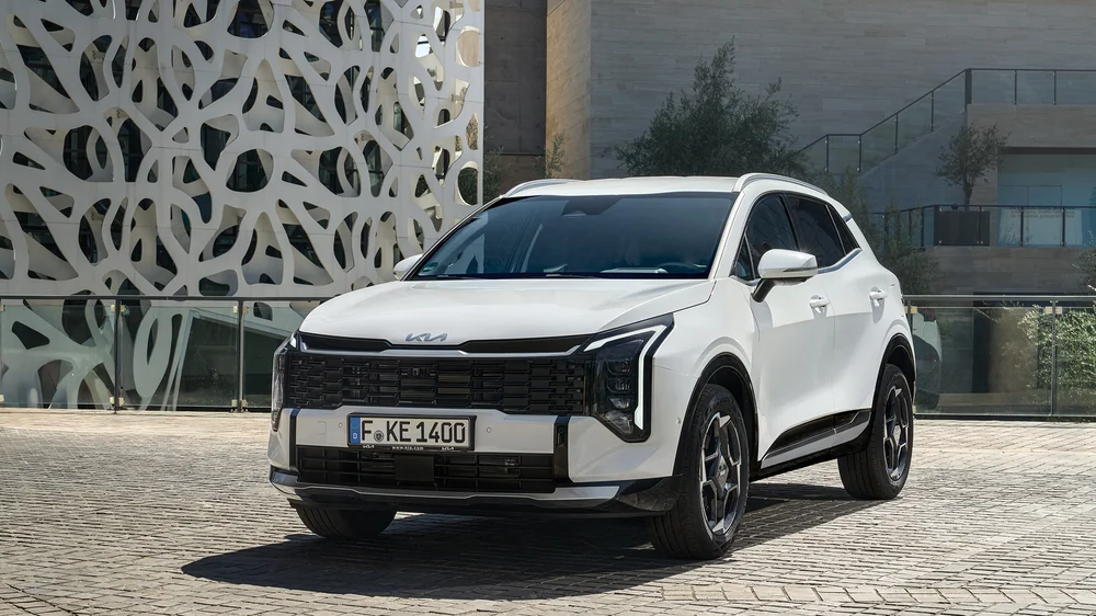 Bílý SUV Kia Sportage páté generace na kamenném povrchu.