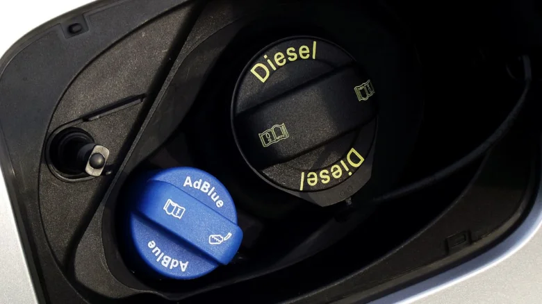 Modrá víčko na tekutinu AdBlue vedle černého dieselového plniče.